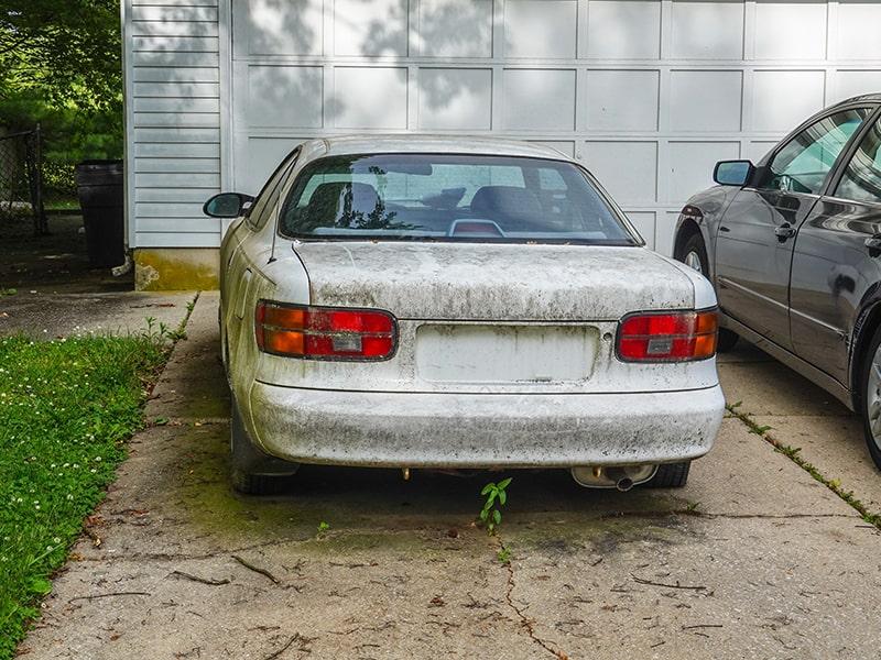 a pile of old rusted cars stacked in a junkyard